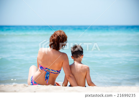 Back view of mother and son sitting on tropical Back view of mother and son sitting on tropical 21699235