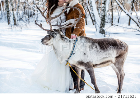 A deer stands next to the bride and groom 21713623