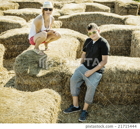 Woman with the son are sitting on the haystack Woman with the son are sitting on the haystack 21715444