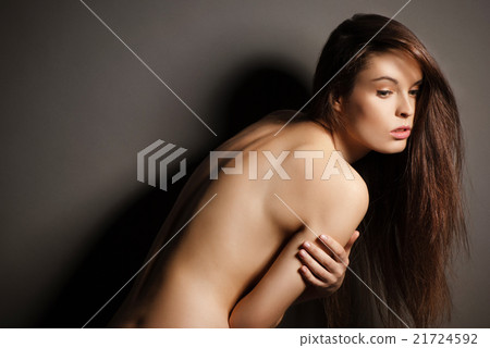 Posing brunette woman with long hair on gray 21724592