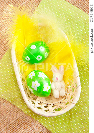 Easter eggs in a basket with yellow feathers Easter eggs in a basket with yellow feathers 21724668