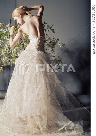 Bride in wedding dress behind bush with flowers Bride in wedding dress behind bush with flowers 21725306