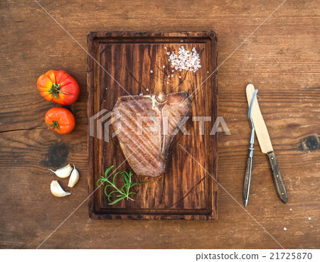 Cooked meat t-bone steak on serving board with Cooked meat t-bone steak on serving board with 21725870