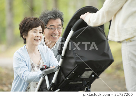 Grandparents smiling at the grandchild who takes a stroller 21727200