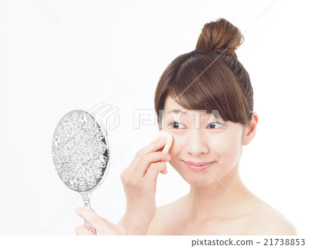 A woman with a beauty hand mirror and a sponge A woman with a beauty hand mirror and a sponge 21738853