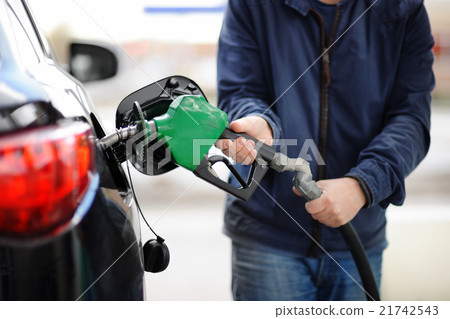 Man pumping gasoline fuel in car at gas station 21742543