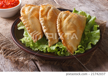 pies empanadas on a plate with lettuce and sauce pies empanadas on a plate with lettuce and sauce 21742837