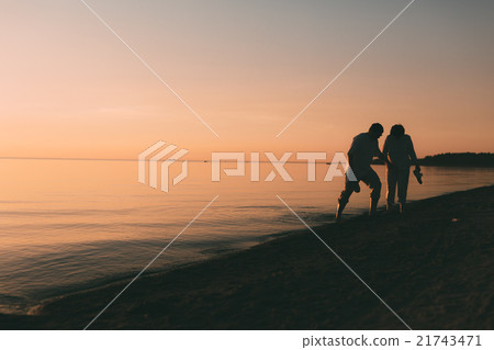 Silhouette of adult couple standing in the sea 21743471