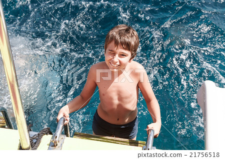 A young boy climbs the stairs from the sea A young boy climbs the stairs from the sea 21756518