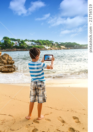 The young man traveler photographing sea The young man traveler photographing sea 21756519
