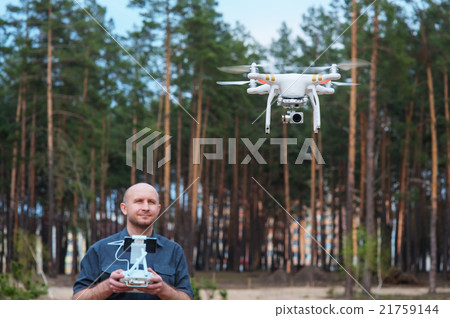 Man using his drone outdoor with forest background 21759144