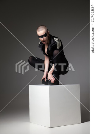 agressive bald sitting woman with mask makeup 21761684