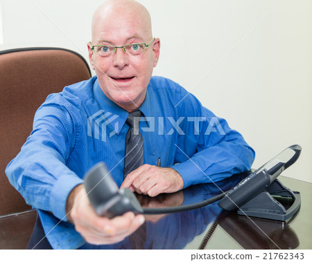 Executive at desk handing over phone Executive at desk handing over phone 21762343