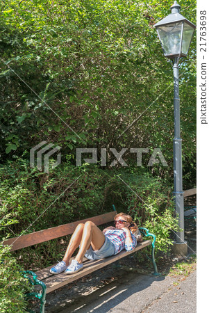 Sad woman lying on a park bench. Sad woman lying on a park bench. 21763698