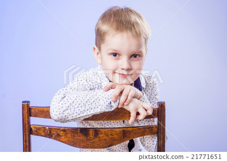Portrait of cute little boy on chair 21771651