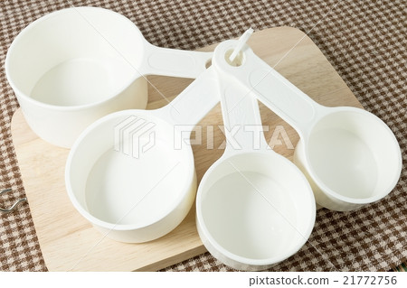 Four Plastic Measuring Cups on Wooden Board Four Plastic Measuring Cups on Wooden Board 21772756