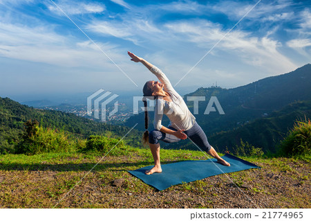 Woman practices yoga asana Utthita Parsvakonasana 21774965
