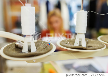 Close up of two white threads on sewing machine 21777202