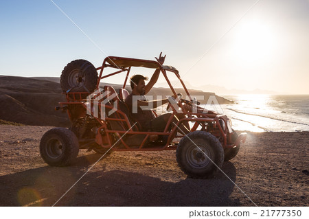 Man driving quadbike in sunset. 21777350