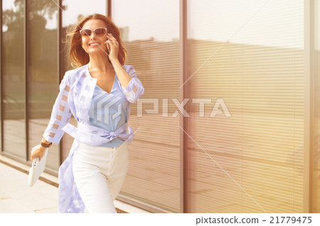 Businesswoman talking over mobile phone Businesswoman talking over mobile phone 21779475