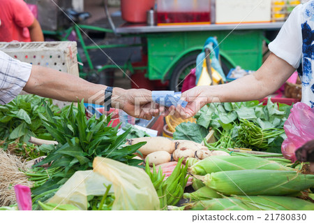 Buyer pays for purchases at the street market Buyer pays for purchases at the street market 21780830