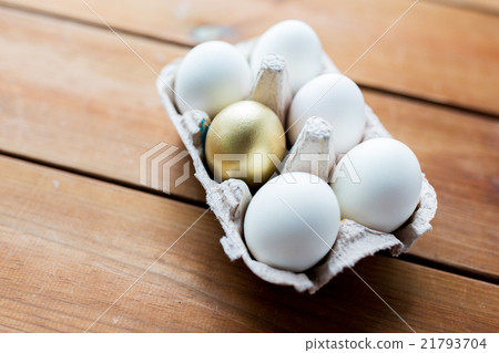 close up of white and gold eggs in egg box 21793704