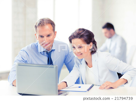 man and woman working with laptop in office man and woman working with laptop in office 21794739