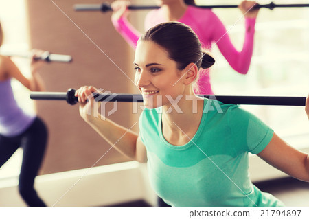 group of people exercising with bars in gym 21794897