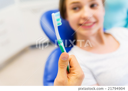 close up of dentist hand with toothbrush and girl 21794904