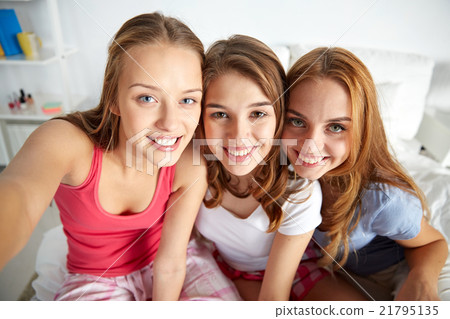 happy friends or teen girls taking selfie at home happy friends or teen girls taking selfie at home 21795135