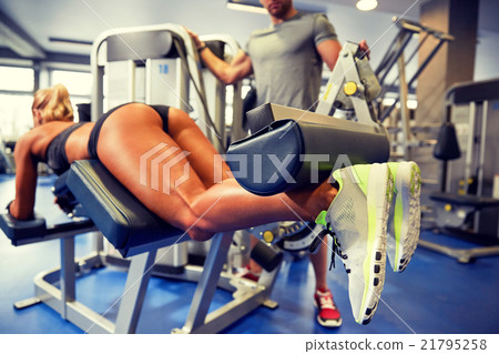 man and woman flexing muscles on gym machine 21795258