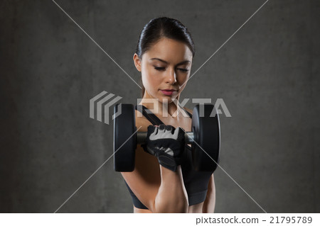 young woman flexing muscles with dumbbells in gym young woman flexing muscles with dumbbells in gym 21795789
