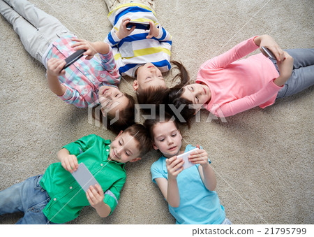 happy children with smartphones lying on floor happy children with smartphones lying on floor 21795799