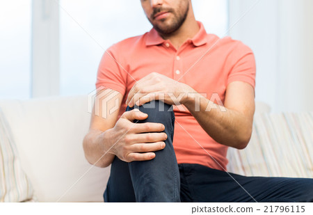 close up of man suffering from pain in leg at home close up of man suffering from pain in leg at home 21796115