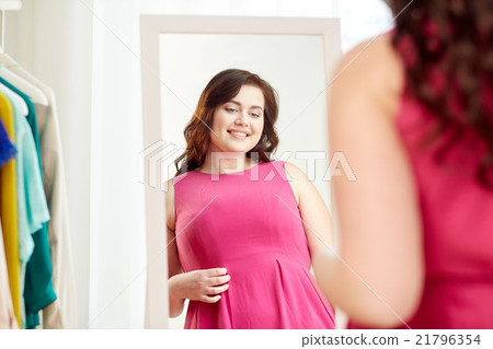 happy plus size woman posing at home mirror 21796354