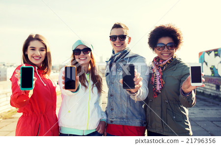 smiling friends showing blank smartphone screens smiling friends showing blank smartphone screens 21796356