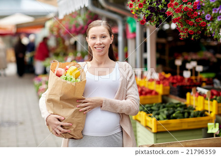 pregnant woman with bag of food at street market pregnant woman with bag of food at street market 21796359