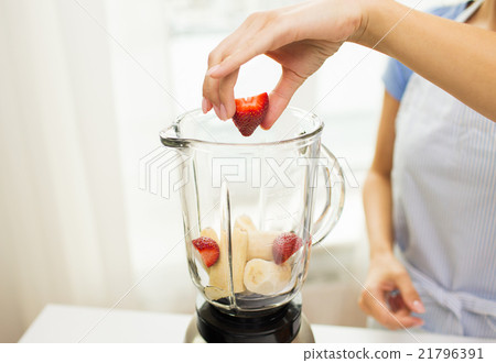 close up of woman with blender making fruit shake close up of woman with blender making fruit shake 21796391