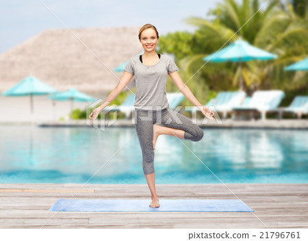 woman making yoga in tree pose on mat woman making yoga in tree pose on mat 21796761