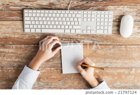 close up of hands with notebook and keyboard 21797124