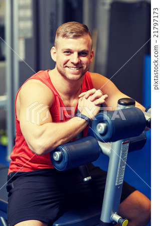 smiling man sitting on exercise bench in gym smiling man sitting on exercise bench in gym 21797173