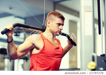 man flexing muscles on cable machine gym man flexing muscles on cable machine gym 21797270