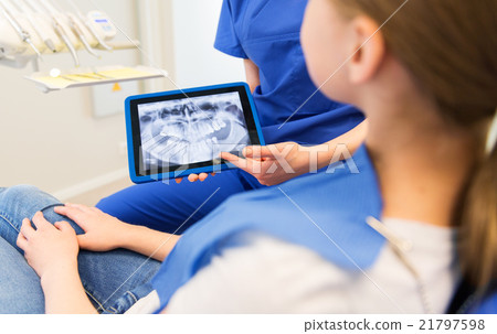 dentist showing x-ray on tablet pc to patient girl 21797598