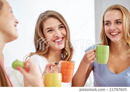happy young women drinking tea with sweets at home happy young women drinking tea with sweets at home 21797605