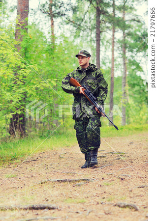 young soldier or hunter with gun in forest 21797666