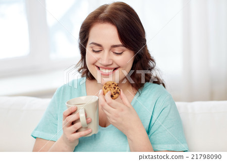 happy plus size woman with cup and cookie at home happy plus size woman with cup and cookie at home 21798090