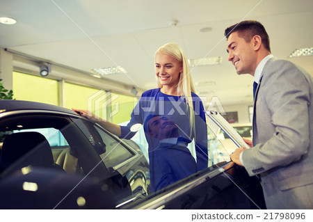 happy woman with car dealer in auto show or salon 21798096