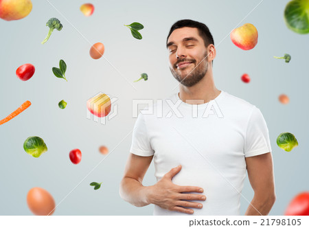 happy full man touching tummy over falling fruits happy full man touching tummy over falling fruits 21798105
