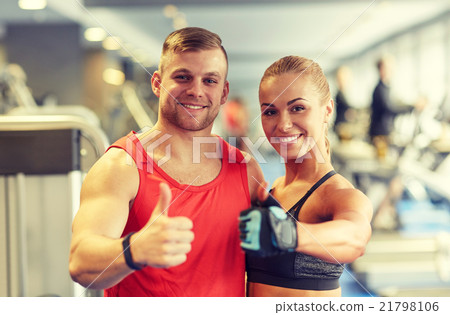 smiling man and woman showing thumbs up in gym smiling man and woman showing thumbs up in gym 21798106