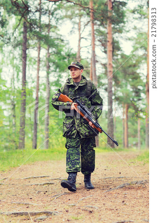 young soldier or hunter with gun in forest 21798313